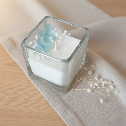 Candela decorativa in cera di soia con fiori secchi azzurri e contenitore in vetro quadrato