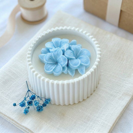 Bomboniere artigianali candele in cera di soia naturale con fiore di plumeria azzurro in rilievo, ideale per matrimoni ed eventi