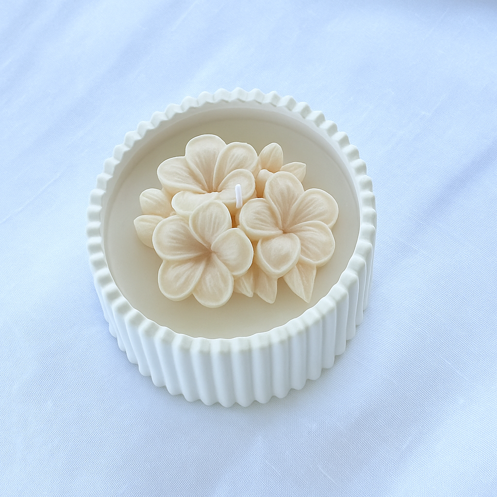 Bomboniera artigianale candela in cera di soia naturale con fiore di plumeria beige in rilievo, ideale per matrimoni ed eventi