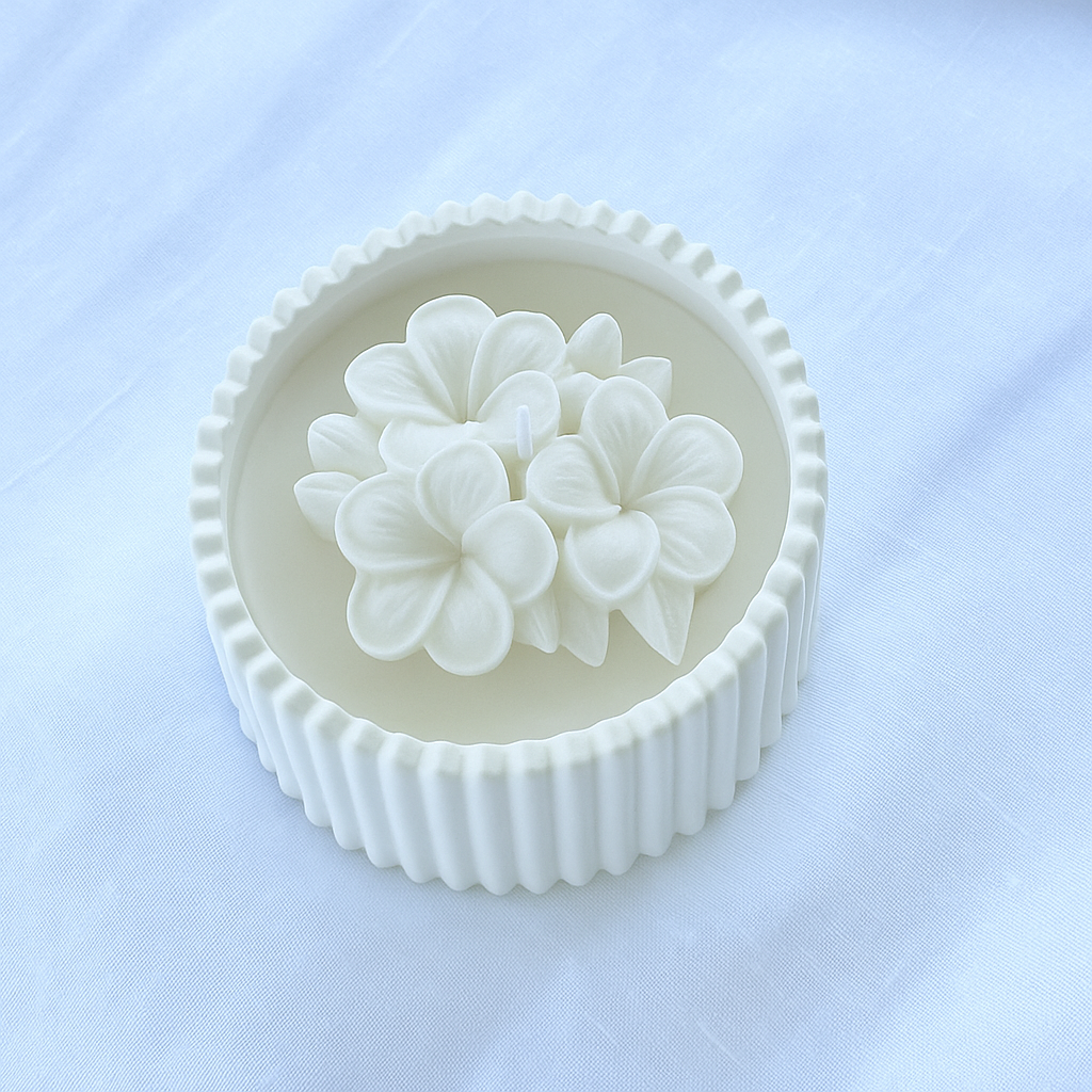 Bomboniera artigianale candela in cera di soia naturale con fiore di plumeria bianco in rilievo, ideale per matrimoni ed eventi