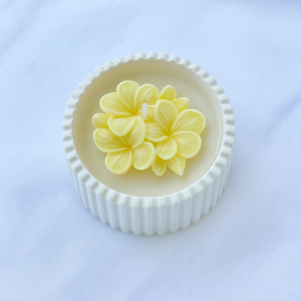 Bomboniera artigianale candela in cera di soia naturale con fiore di plumeria giallo in rilievo, ideale per matrimoni ed eventi