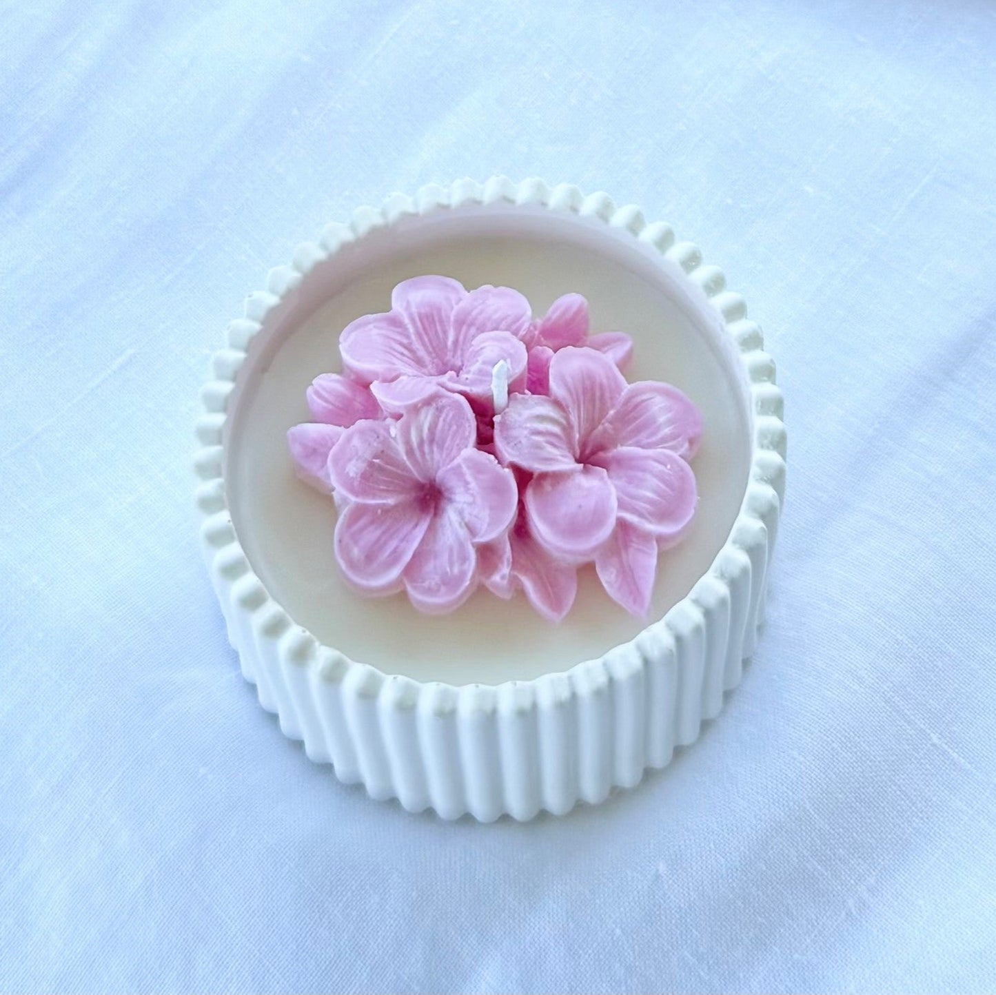 Bomboniera artigianale candela in cera di soia naturale con fiore di plumeria rosa in rilievo, ideale per matrimoni ed eventi