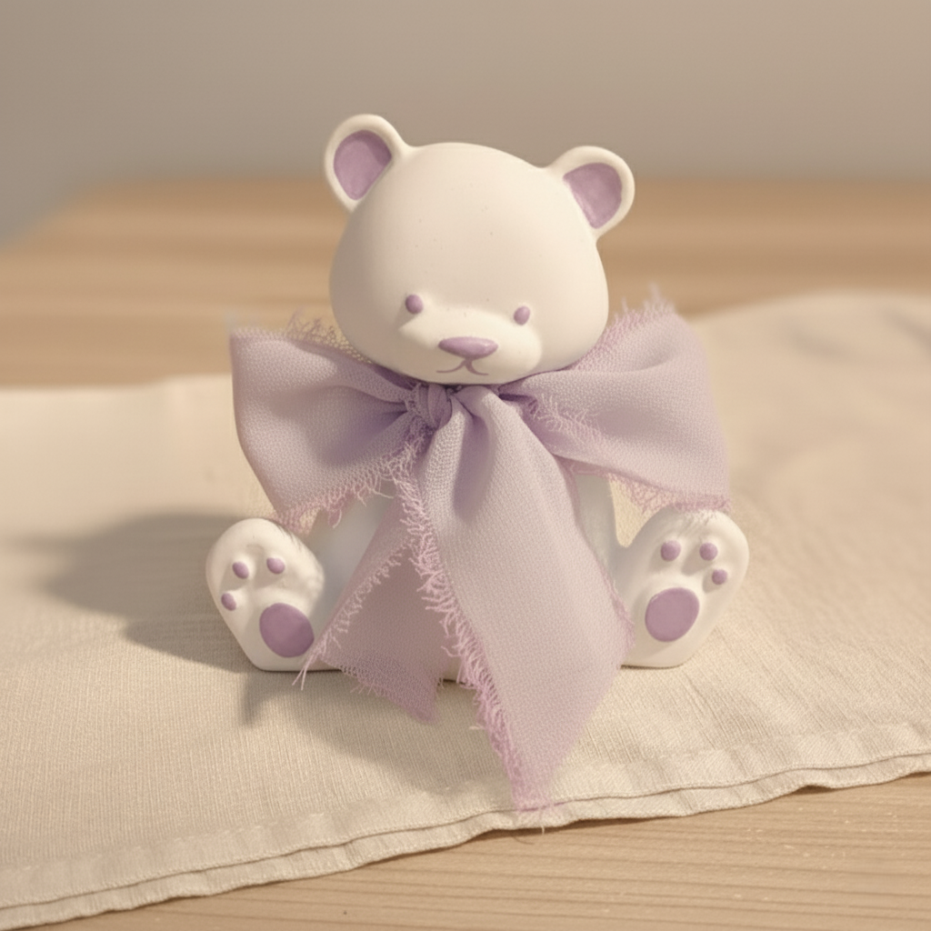 Bomboniera artigianale a forma di orsetto in ceramica con dettagli lilla e nastro in chiffon lilla, ideale per baby shower e nascita