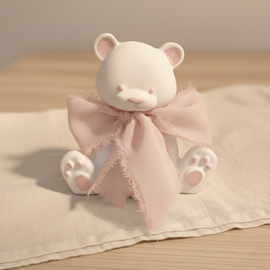 Bomboniera artigianale a forma di orsetto in ceramica con dettagli rosa e nastro in chiffon rosa, ideale per baby shower e nascita