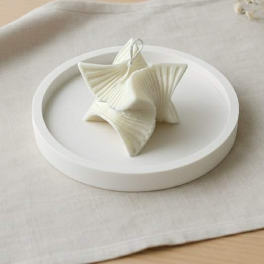 Candela artigianale in cera di soia naturale dalla forma a spirale che richiama una stella con base in polvere di ceramica, ideale come complemento d’arredo