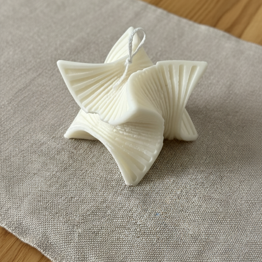 Candela artigianale in cera di soia naturale dalla forma a spirale che richiama una stella, ideale come complemento d’arredo